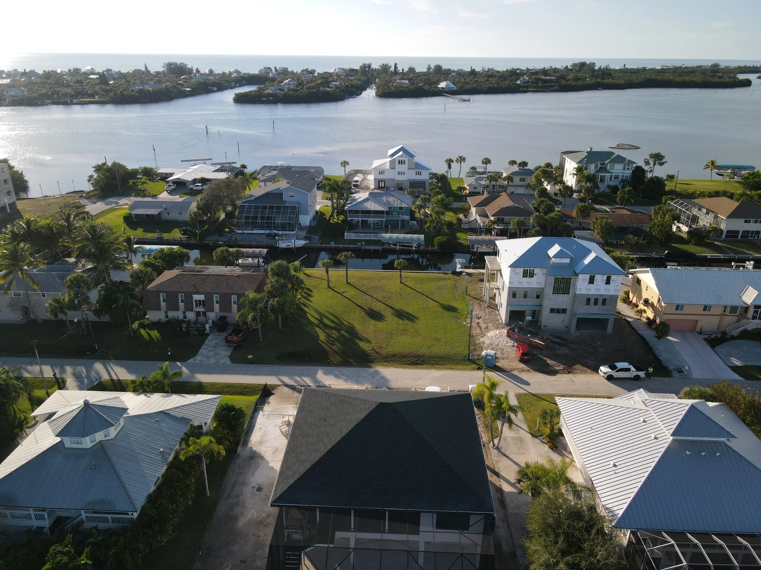 Single-story house with a two-car garage, neatly trimmed lawn, small palm trees, and a "For Rent" sign in the front yard beneath a clear blue sky—ideal for those seeking Homes for Rent in Naples.