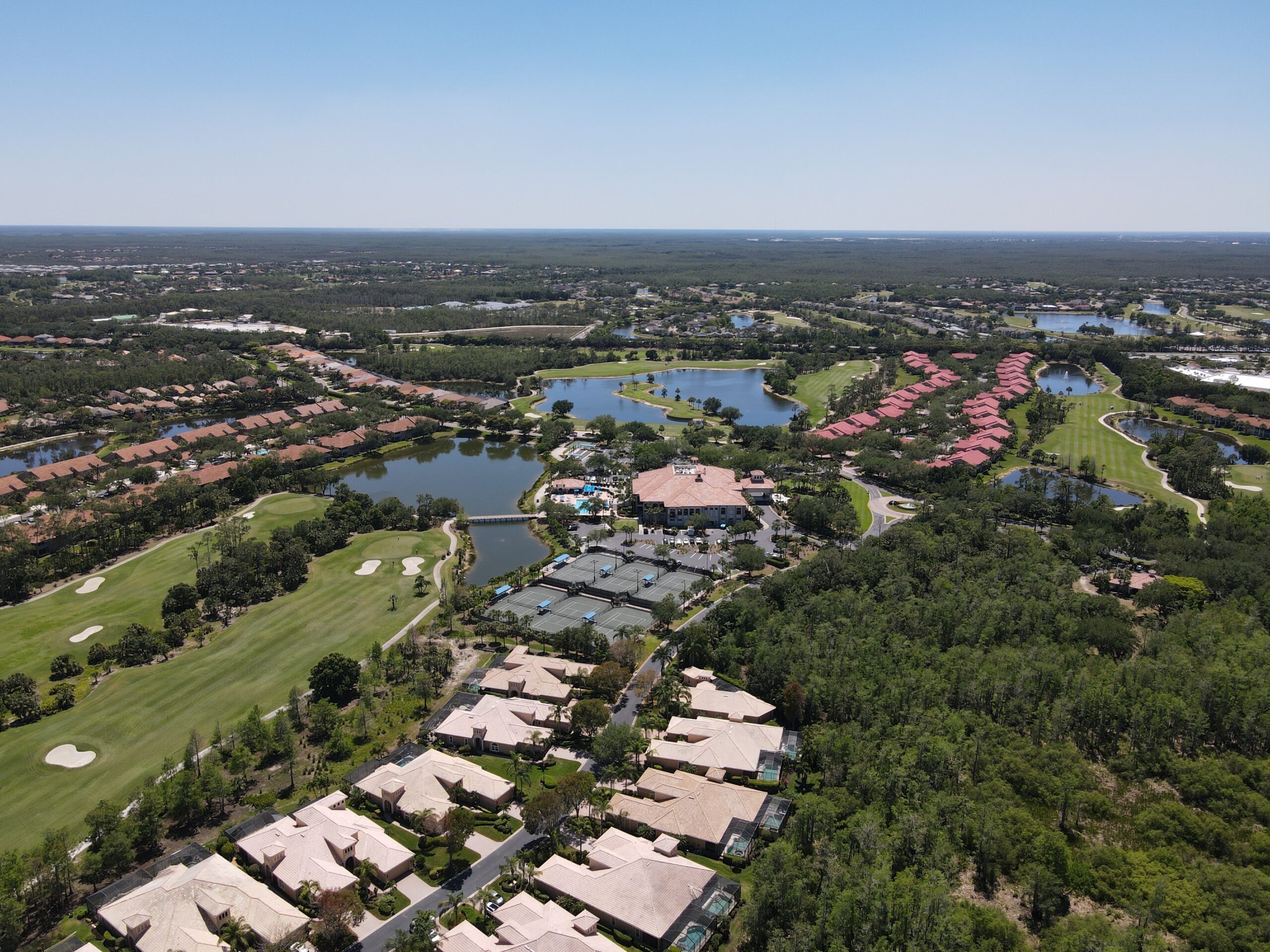Single-story house with a two-car garage, neatly trimmed lawn, small palm trees, and a "For Rent" sign in the front yard beneath a clear blue sky—ideal for those seeking Homes for Rent in Naples.