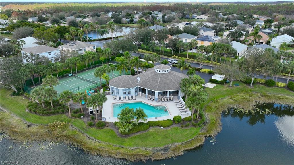 Single-story Jacaranda home with a gray roof, light pink walls, one-car garage, and concrete driveway. The 4 bedroom layout features two palm trees in the front yard and power lines overhead.